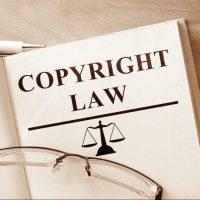 Book with words Copyright Law and glasses. Book with words Copyright Law and glasses.
